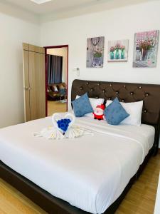a bedroom with a large white bed with blue pillows at Cher Cher Pool Villa in Ban Chang +50 photos
