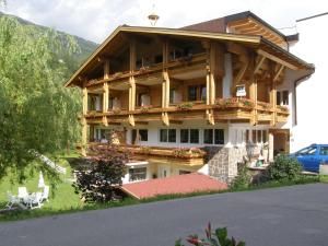 a large wooden house with a balcony and a car at Sportalm in Sölden