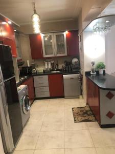 a kitchen with red cabinets and a washer and dryer at La vista 5 ain sokhna Luxury sea view عين سخنة لا فيستا in Ain Sokhna