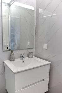 un bagno bianco con lavandino e specchio di Hera House, Ponta do Sol, Portugal a Canhas Altre 16 foto