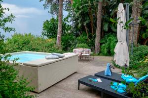 a patio with a couch and an umbrella and a pool at Villa La Capperina in Capri
