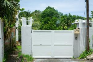 a white garage door in front of a house at Vacances agréables c'est ici in Les Abymes