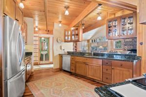 a large kitchen with wooden cabinets and a refrigerator at RMR: The Village House in Teton Village in Teton Village