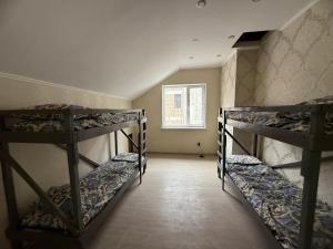 ビシュケクにあるSun City Hostelの窓のある部屋に二段ベッドが3つある