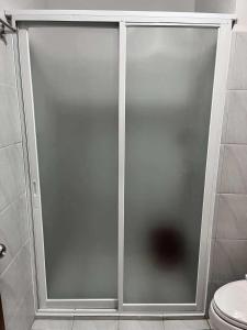 a glass shower door in a bathroom with a toilet at Casa Mira Towers Guadalupe Condo in Cebu City +11 photos