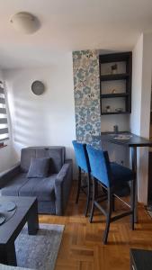 a living room with a couch and a table and chairs at Zlatiborski konaci 14 Pet Frendly! in Zlatibor