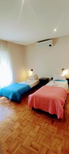 a bedroom with two beds and a wooden floor at Casa de Férias Privada in Amares