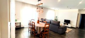 a living room with a table and a couch at Casa com jardim privado e estacionamento no interior in Amares