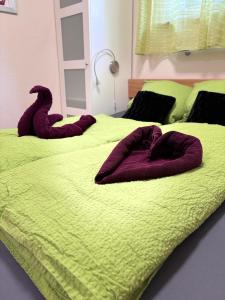 two beds with purple towels on them in a bedroom at MeLou FeWo NaturQuartier Wellness in Bad Lauterberg