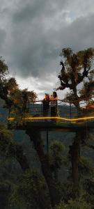 two people standing on top of a bridge at MOZO Inn&Cafe Jibhi in Banjār +102 photos