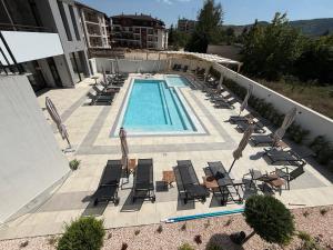 an overhead view of a swimming pool with chaise lounge chairs at Nikol5 Deluxe in Velingrad