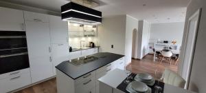 una cucina con mobili bianchi e un piano di lavoro nero di Wohnen auf Zeit in der Maritim Residenz a Kiel