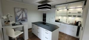 una cucina con mobili bianchi e un piano di lavoro nero di Wohnen auf Zeit in der Maritim Residenz a Kiel