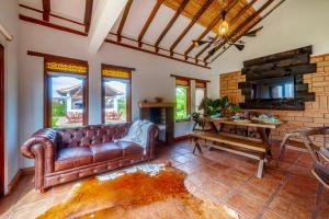 a living room with a leather couch and a table at Chalet Privado in Villa de Leyva