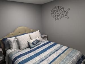 a bedroom with a bed with a blue and white striped blanket at The Calico Cottage in Lewis Center