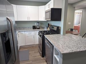 a kitchen with white cabinets and a stove top oven at The Calico Cottage in Lewis Center +16 photos