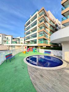 een groot appartementengebouw met een speeltuin voor een gebouw bij Paraiso dos Anjos in Arraial do Cabo