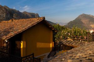 a small building with mountains in the background at Khói Bản Homestay in Dồng Văn