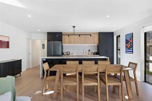 a kitchen and dining room with a table and chairs at Alpenglow Lodge with steam sauna in Queenstown