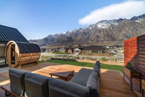a patio with a couch and a table and mountains at Alpenglow Lodge with steam sauna in Queenstown