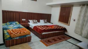 a bedroom with two beds and a rug at Laxmanji villas in Mount Ābu