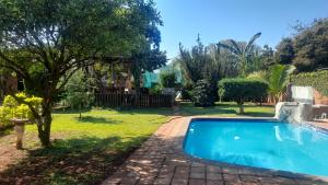 a swimming pool in the yard of a house at Sol & Sombra Guesthouse in Komatipoort