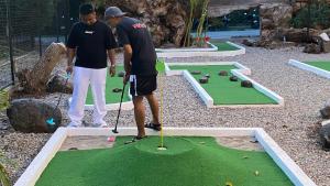 two men playing golf on a miniature golf course at Mad Monkey Dumaguete in Dumaguete