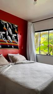a bedroom with a large bed and a window at Eden One in Ilhéus