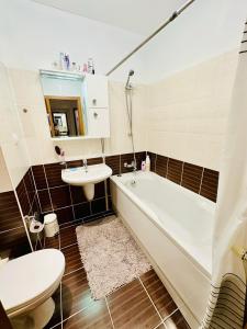 a bathroom with a tub and a sink and a toilet at Borovets Hills Hotel & Spa Apartment in Bŭnzareto