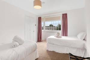 ein weißes Zimmer mit zwei Betten und einem Fenster in der Unterkunft Sand Dancer Haven - North East Escapes in South Shields