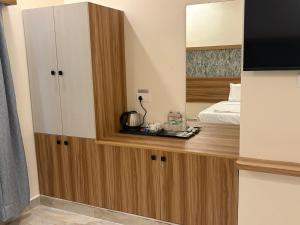 Una cocina con un armario y una cama en una habitación. en Vainavi Residency, en Tirupati