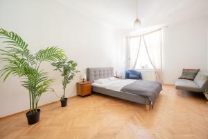 a bedroom with a bed and two potted plants at The City Gem in Bratislava