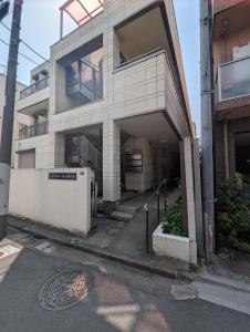 a building with a parking lot in front of it at Nomado Base at YOYOGI in Tokyo +11 photos