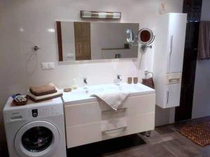 a bathroom with a washing machine and a sink at Apart Mahdia in Mahdia