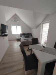 a bedroom with a bed and a table and a couch at Oaza apartman in Soko Banja +9 photos