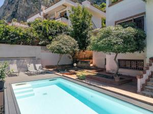 a villa with a swimming pool in front of a house at LuminHouse Addaura Pool in Palermo