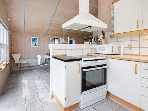 a kitchen with white cabinets and a stove top oven at 8 person holiday home in Henne in Henne Strand