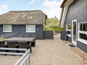 a patio with a table and chairs in front of a house at 4 star holiday home in Henne in Henne Strand