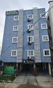 a large blue building with windows on a street at Hotel Airport Shine Inn in Hyderabad