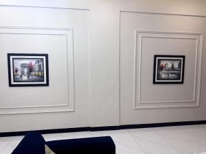 two framed photographs on a white wall in a room at Holiday One Hotel & Suites - Expo Center in Karachi +30 photos