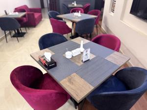 a dining room with purple chairs and a table at Holiday One Hotel & Suites - Expo Center in Karachi