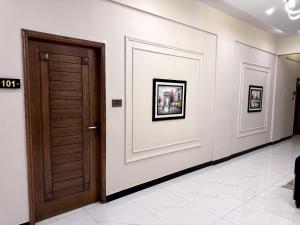 a corridor with a wooden door in a building at Holiday One Hotel & Suites - Expo Center in Karachi