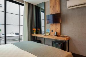 a hotel room with a bed and a television at Mielo Lara Hotel in Antalya