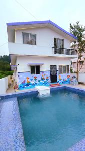 a villa with a swimming pool in front of a house at Bamboo Private Homestay Yercaud in Yercaud