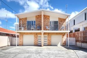 a house with two garage doors in front of it at Popular Central Coastal Apartment in Maroochydore