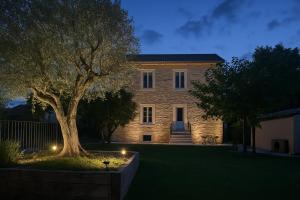 a large stone house with a tree in front of it at La bastide de Sarda in Montélimar