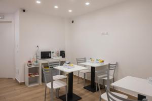 a dining room with two tables and chairs and a microwave at Bed and Breakfast Al Portanova in Reggio di Calabria