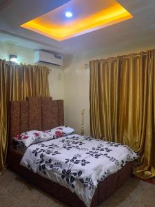 a bedroom with a bed and curtains and a yellow ceiling at Cee&Tee at AKOBO 1Bedroom or 2Bedrooms -247 Electricity-Solar Inverter AC in Bedrooms in Ibadan
