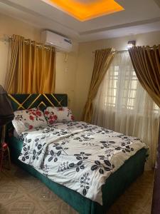 a bedroom with a bed with a black and white comforter at Cee&Tee at AKOBO 1Bedroom or 2Bedrooms -247 Electricity-Solar Inverter AC in Bedrooms in Ibadan +40 photos