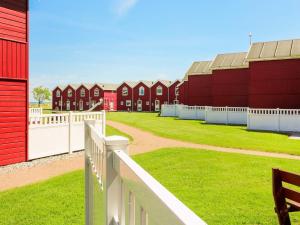 une rangée de bâtiments rouges avec une clôture blanche dans l'établissement Seaside Retreat in oster Hurup-By Traum, à Hadsund